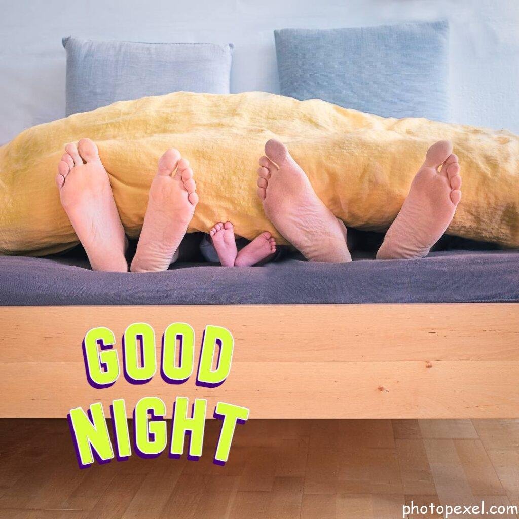 Family-Of-Three-Lying-On-Bed-Showing-Feet-While-Covered-With-Yellow-Blanket-Good-Night-Images